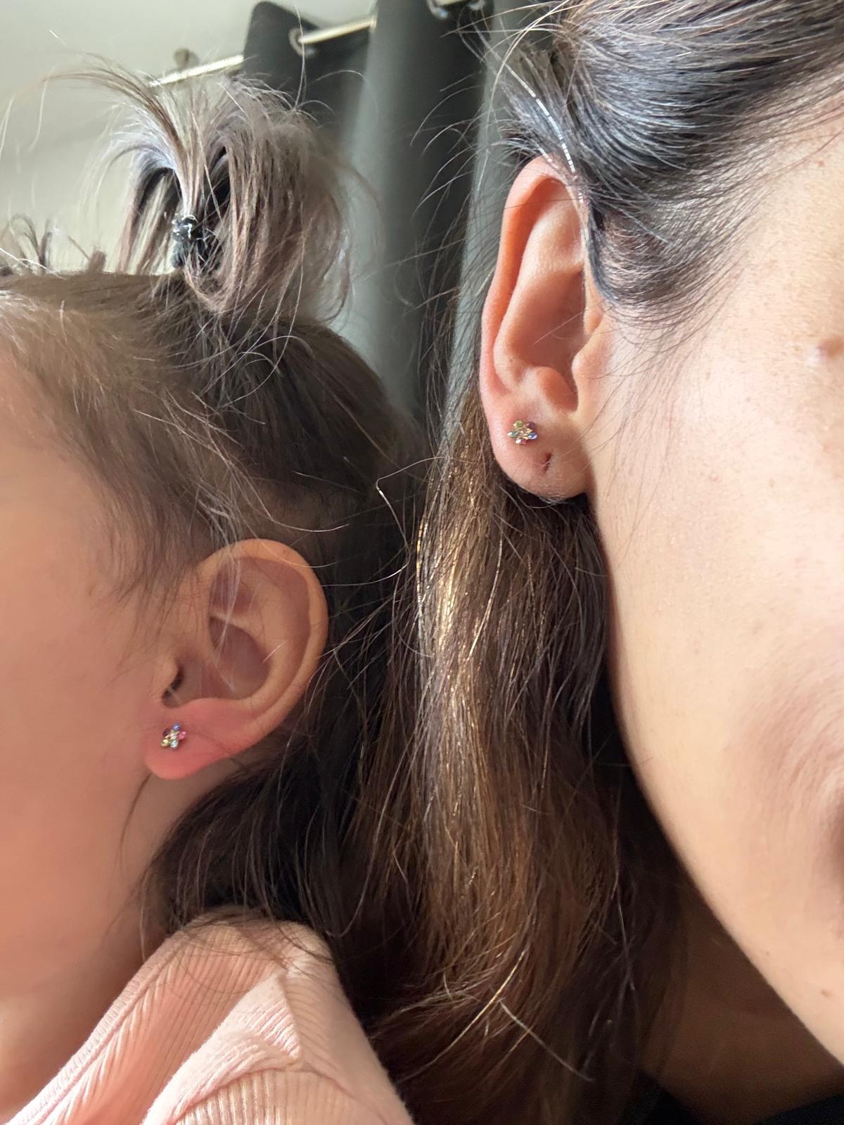 Matching flower earrings on a parent and child after a Real Mama baby ear piercing